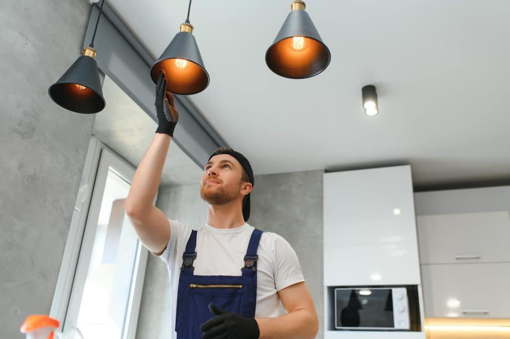 Vancan electrician is installing a lamp in a kitchen lighting project in Langley