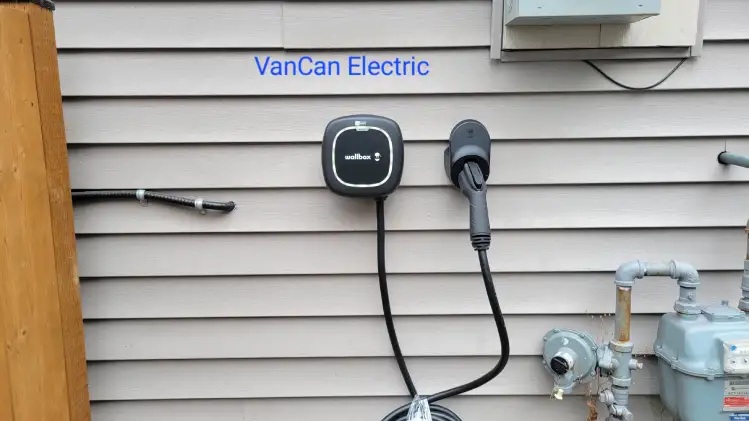 Professional electrician from Vancan Electric installing a Level 2 EV charger at a residential home